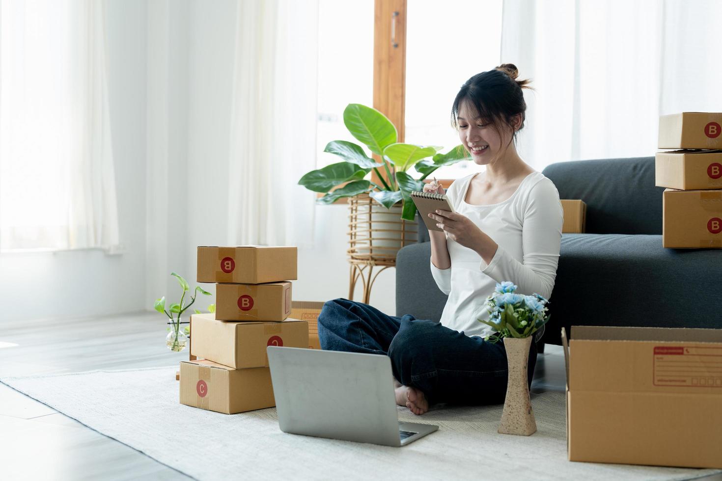 Startup small business owner working with computer at workplace. Freelance woman seller check product order. Packing goods for delivery to customer. Online selling. E-commerce photo