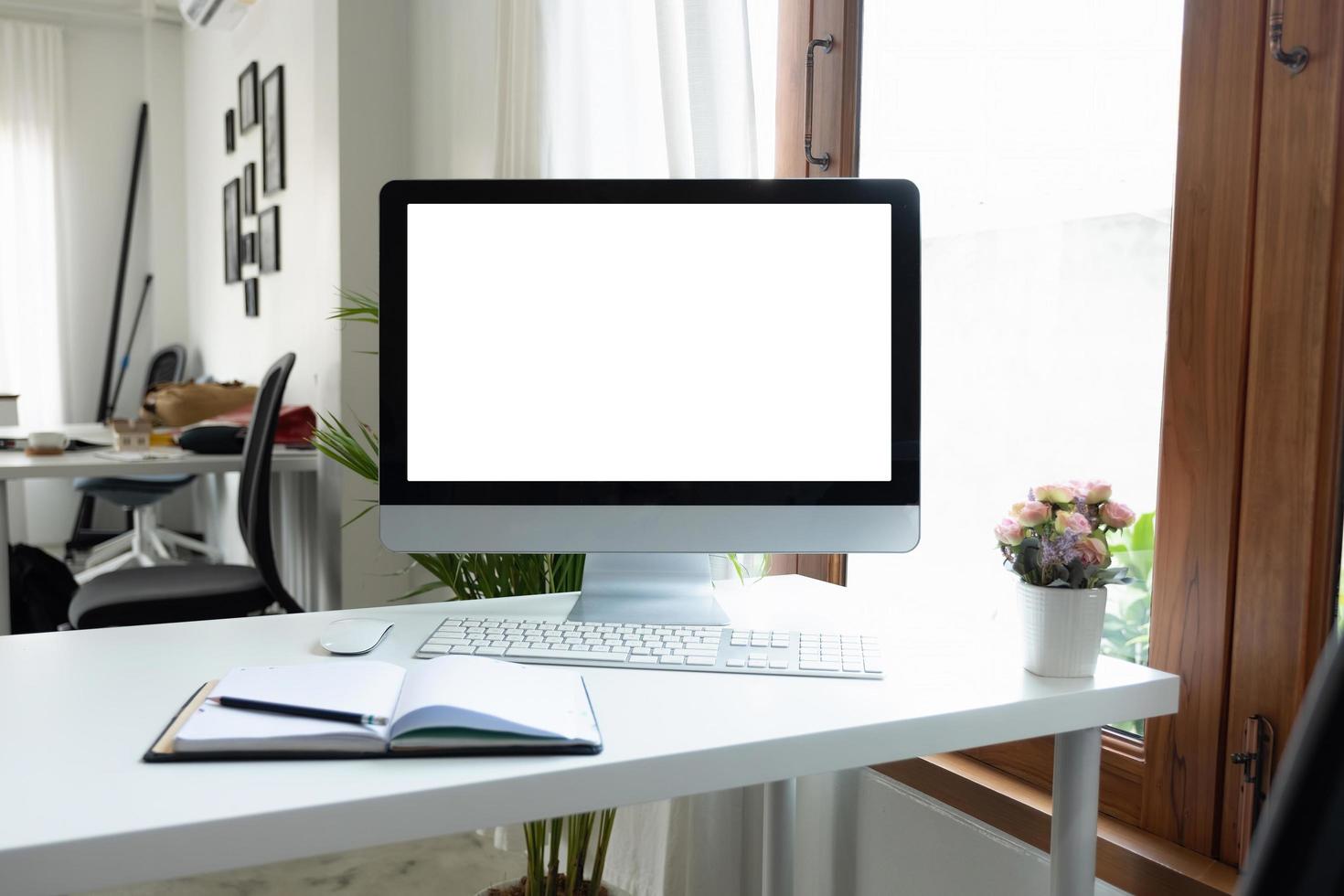 computadora de escritorio con pantalla en blanco en la sala de oficina con decoraciones y espacio para copiar foto