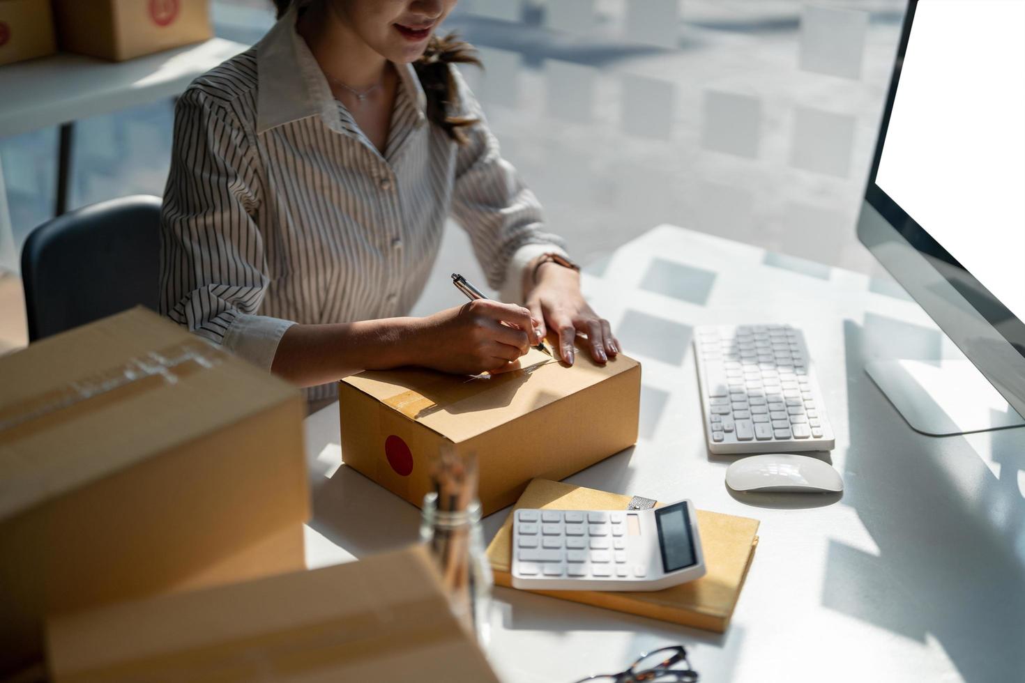 Small start-up business owners checking parcels at work, salespeople, checking production orders. Pack products for delivery to customers photo