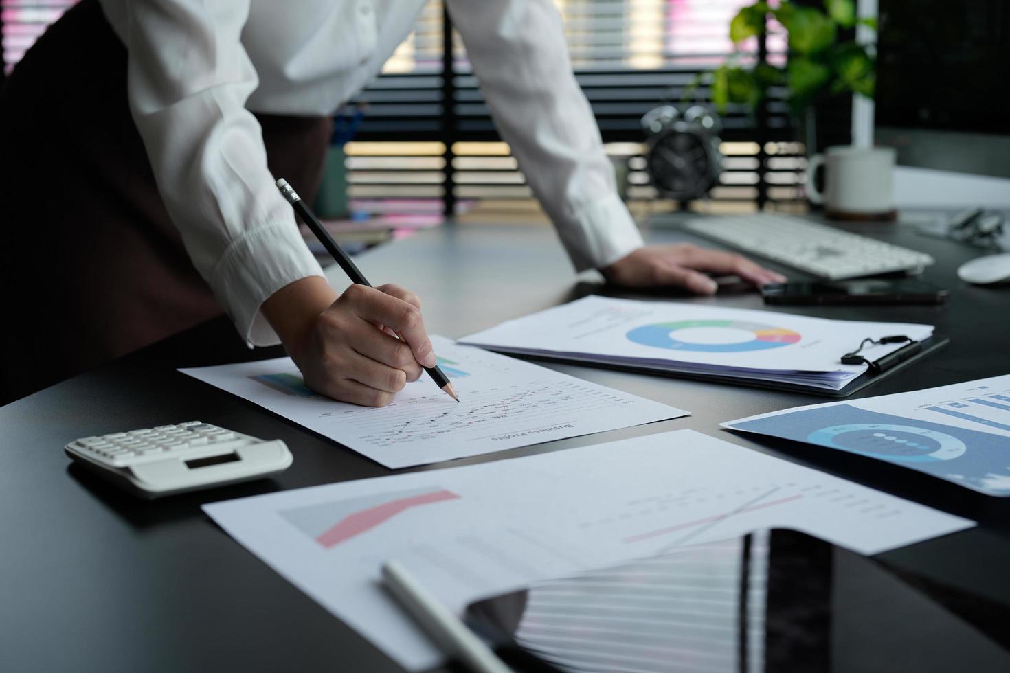 Business woman using calculator for do math finance on wooden desk in office and business working background, tax, accounting, statistics and analytic research concept photo