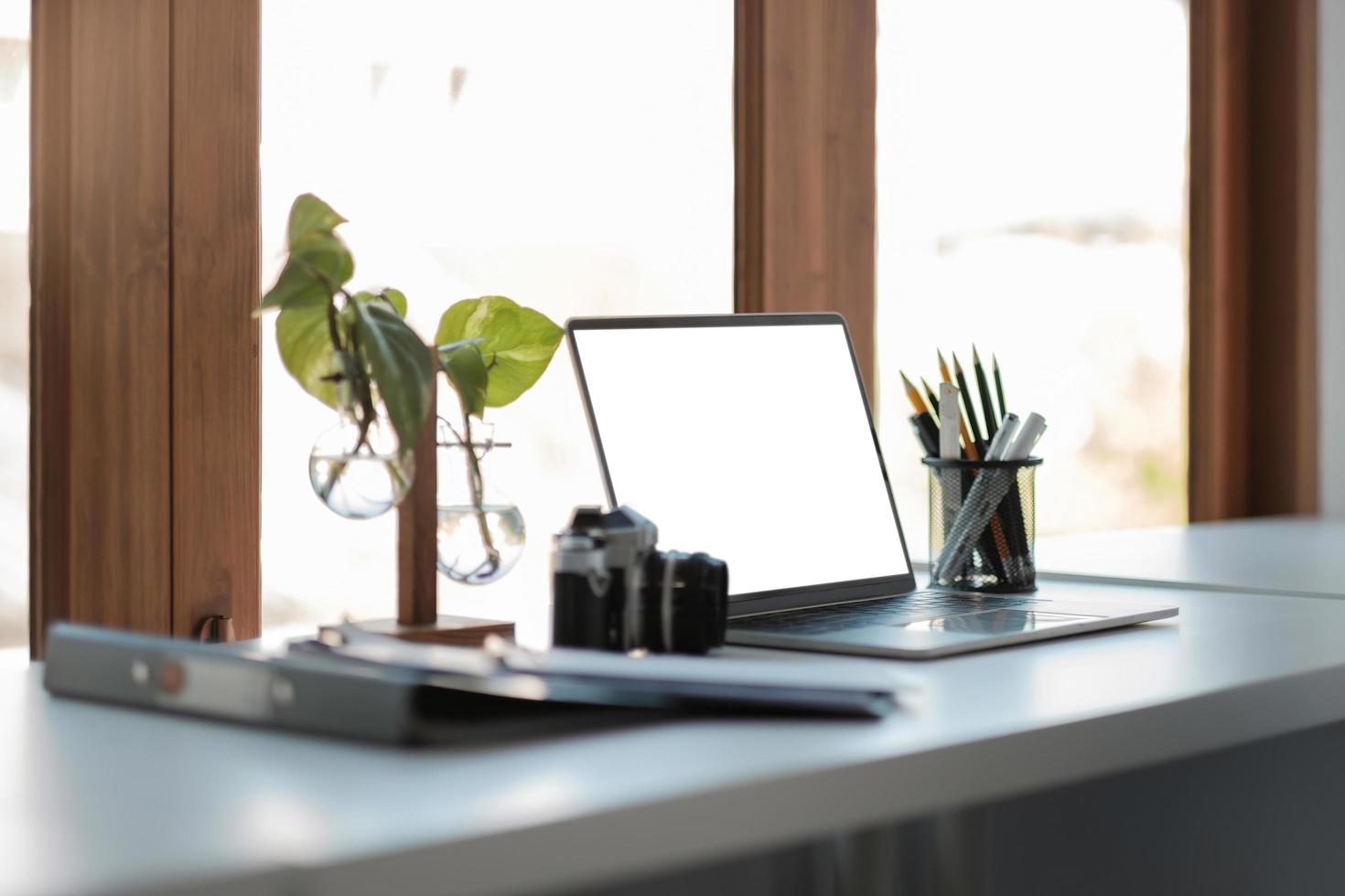 Close up view of laptop computer with blank white screen with office supplies in modern office photo