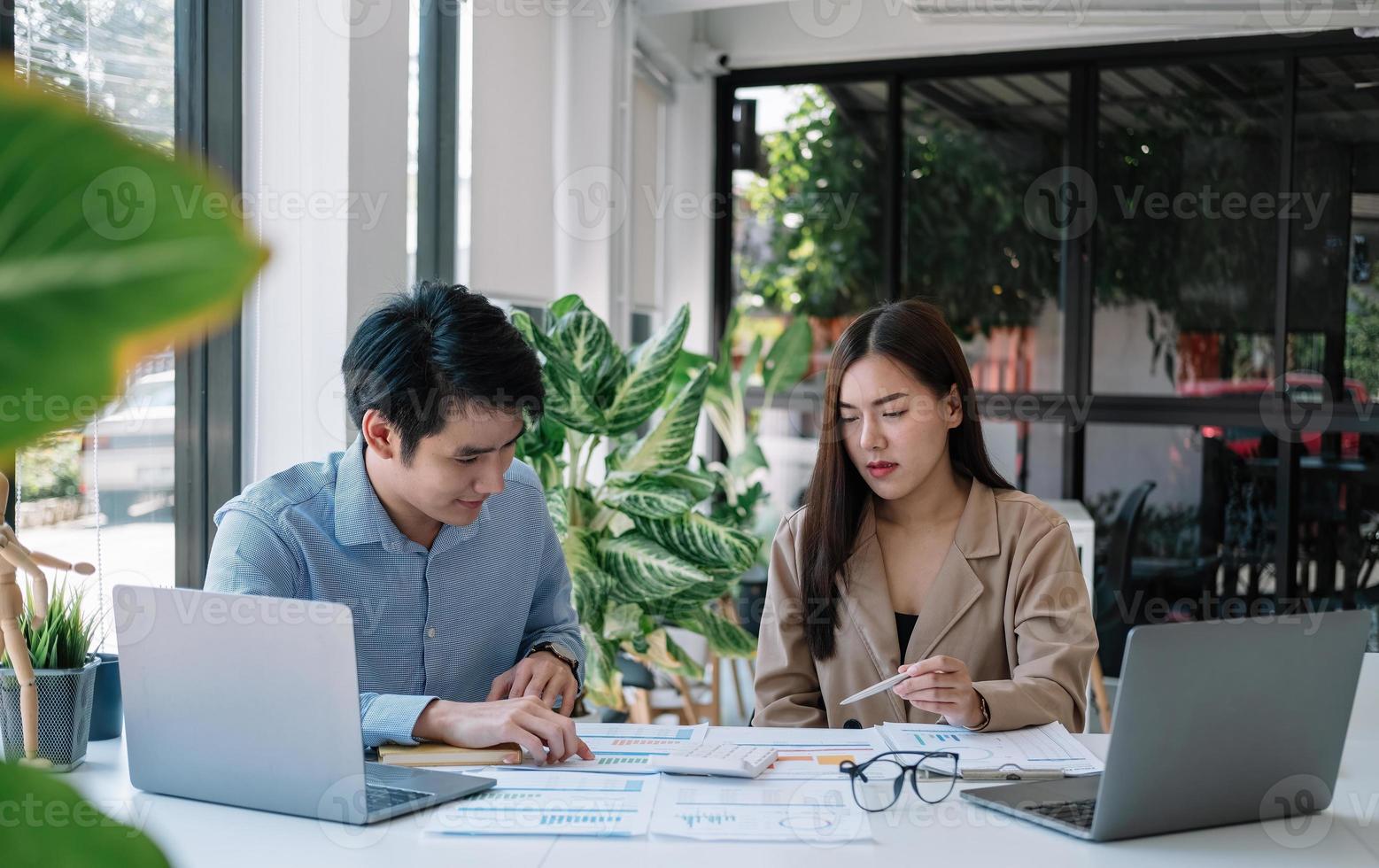Two business asian working together with calculations for paperwork, business startup meeting discuss concept. photo