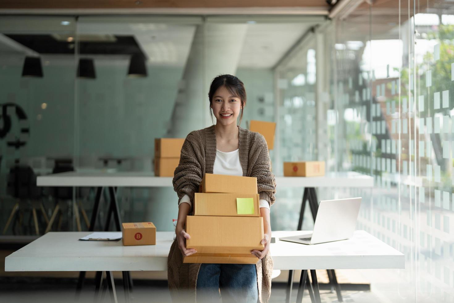 Starting small businesses SME owners female entrepreneurs holding stack of box to review orders online to prepare to pack boxes, sell to customers, online sme business ideas. photo