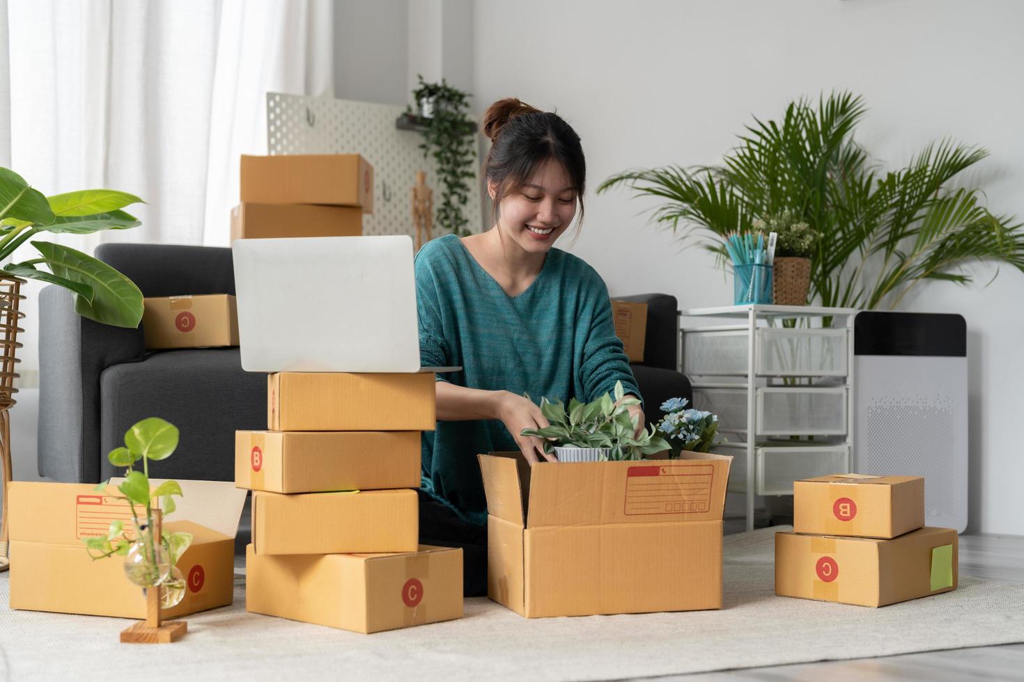 Happy young businessman owner packing plant to cardboard box, Young Owner Woman Start up for Business Online. People with online shopping SME entrepreneur or freelance working concept. photo