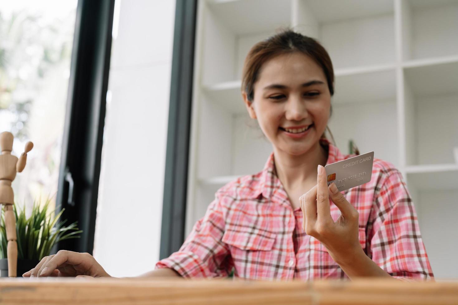 Close up of black girl hold bank credit card and type on laptop, shopping online using computer, buying goods or ordering online, entering bank accounts and details in online banking offer photo