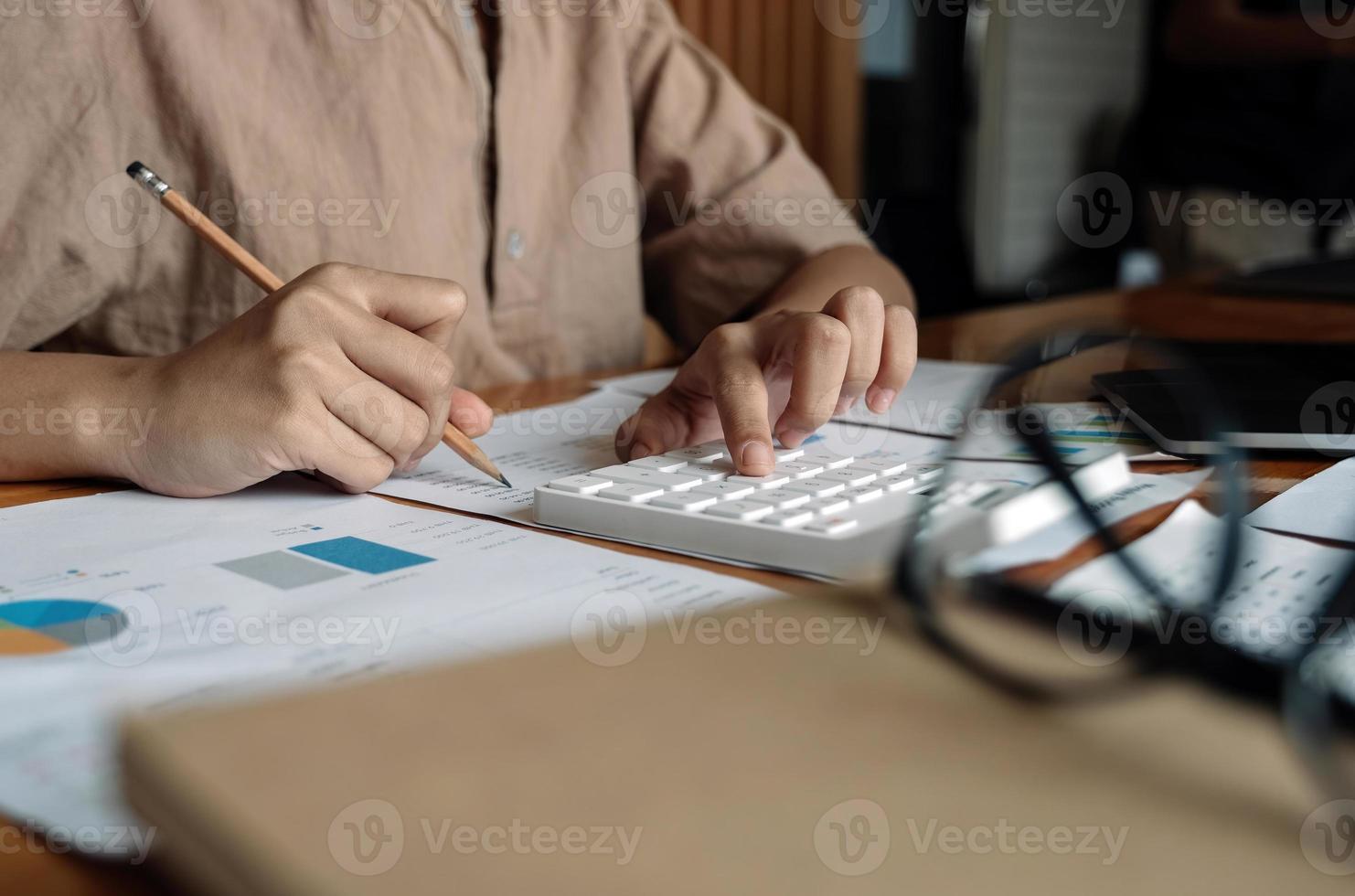 Close up business woman using calculator for do math finance on wooden desk in office and business working background, tax, accounting, statistics and analytic research concept photo