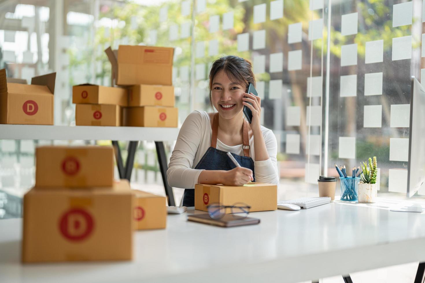 Portrait of Asian young woman SME working with a box at home the workplace.start-up small business owner, small business entrepreneur SME or freelance business online and delivery concept photo