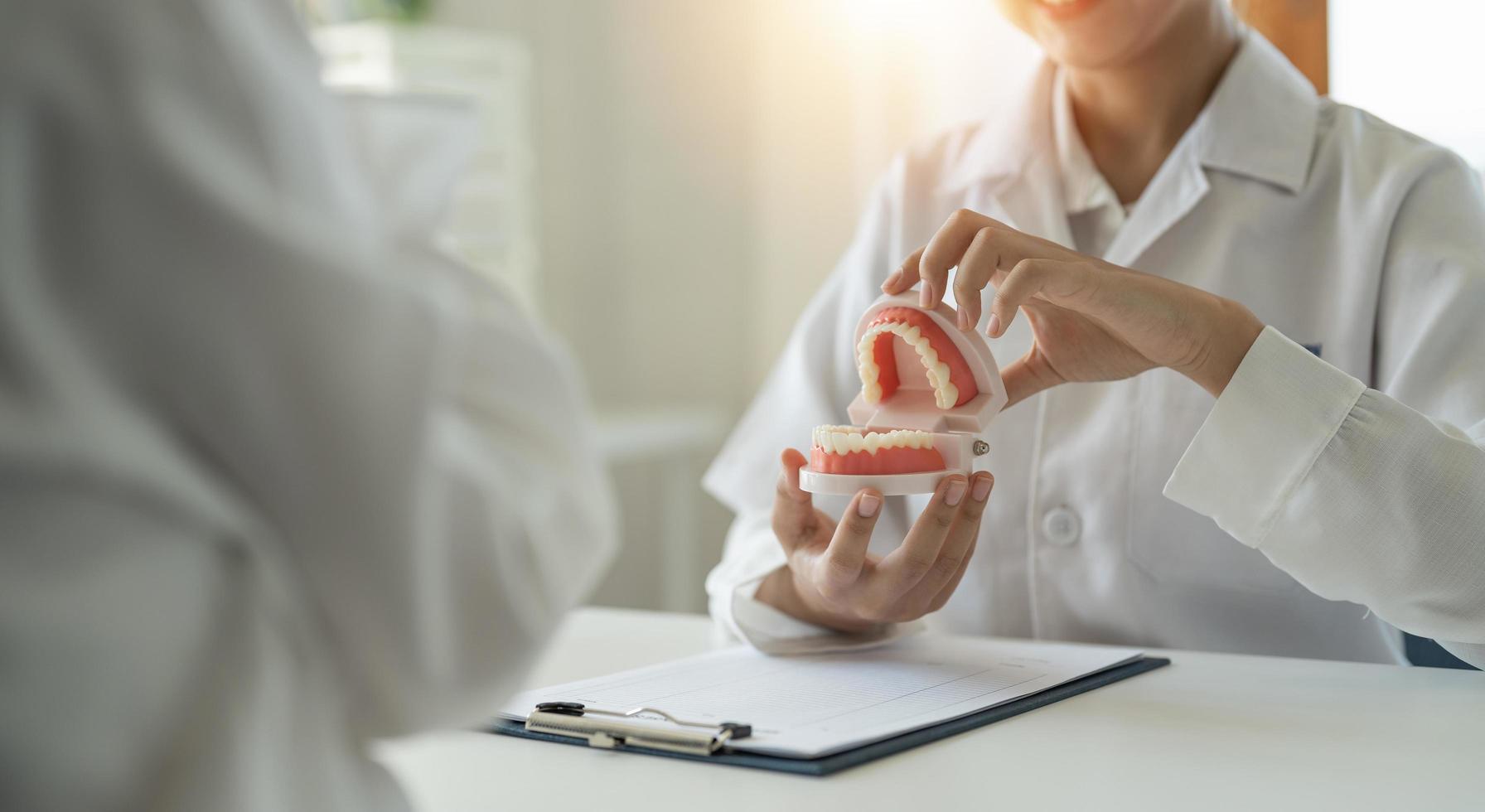 dentist and patient discussion about planned teeth treatment in dental clinic office - dentist consultation concept photo