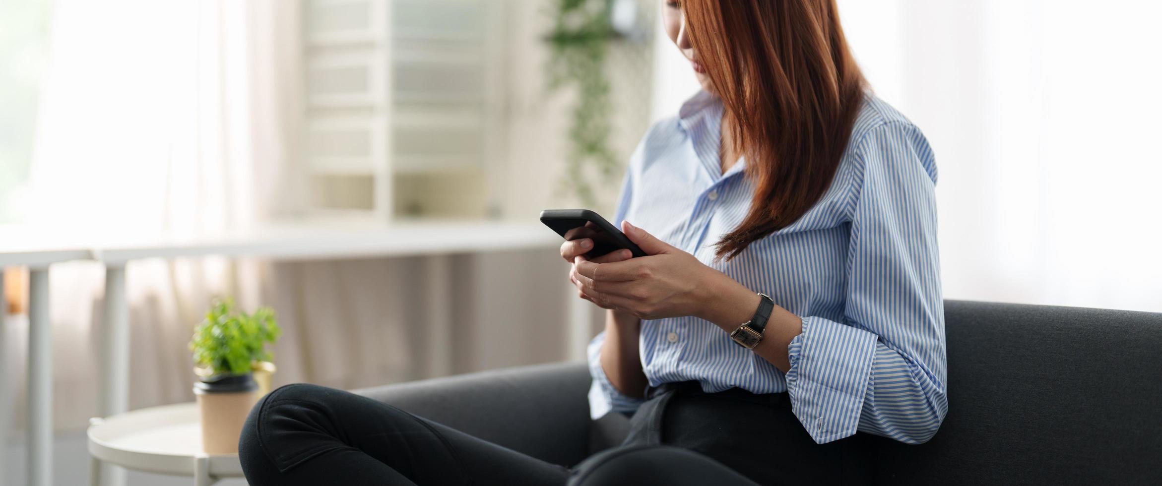 Happy asian girl holding cell phone using smartphone device at home. Smiling young latin woman blogger subscribing new social media, buying in internet, ordering products online in apps. hand close up photo