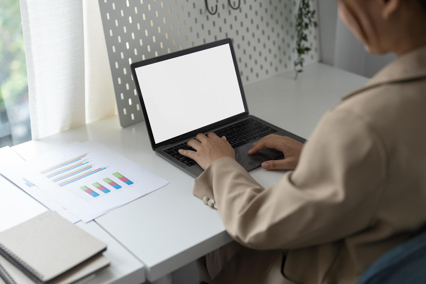 Young man working on his laptop with blank copy space screen for your advertising text message in office, Back view of business man hands busy using laptop at office desk photo