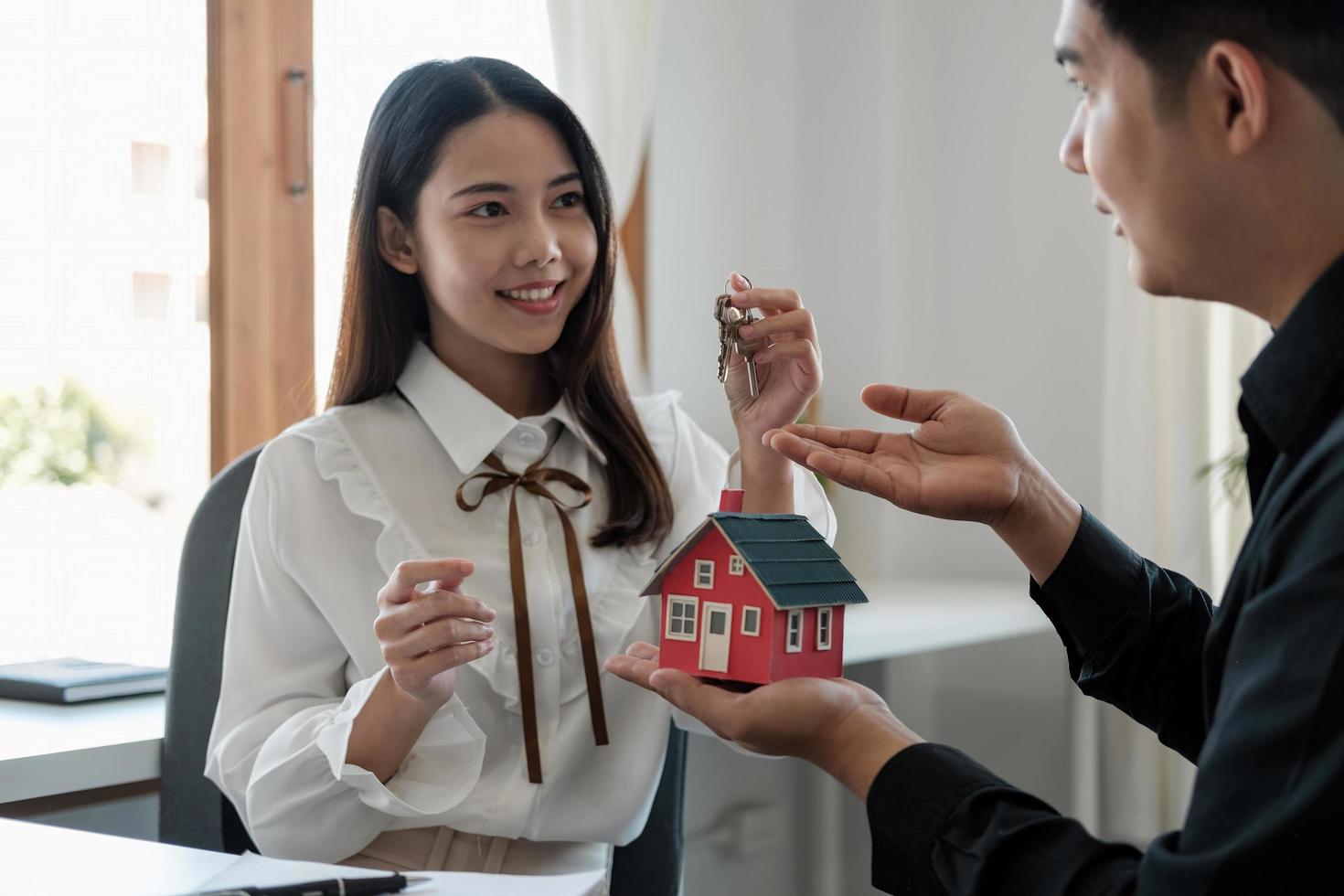 Real estate agent is explaining the house style to the clients who come to contact to see the house design and the purchase agreement photo