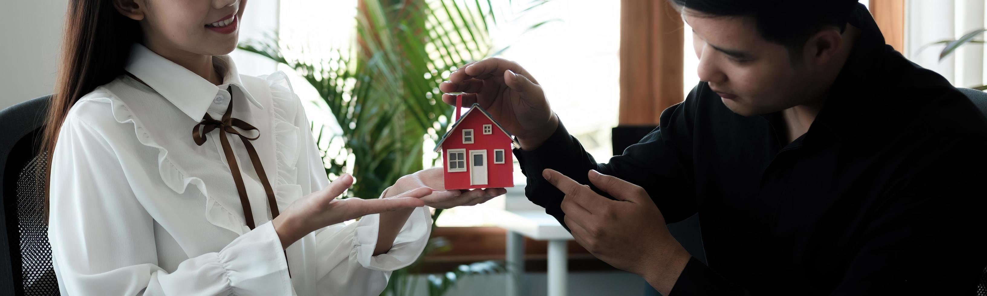 Asian couple are using their hands to protect The concept of the use of gestures in real estate investors, leasing insurance, purchase and sales contracts and maintenance, banner photo
