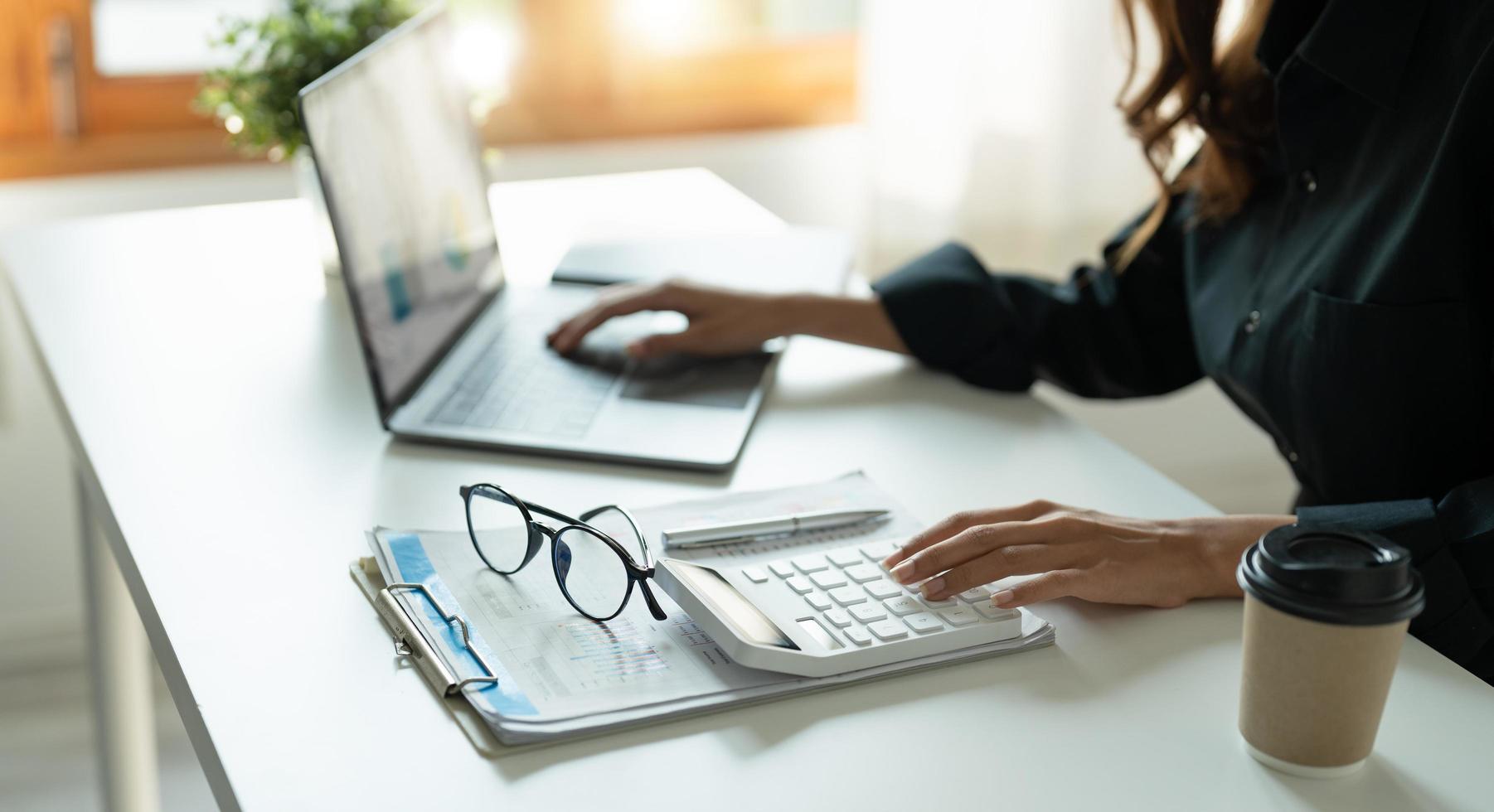 accountant, Auditor, Self-Employed, Finance and Investment, tax calculation and budget, Asian female entrepreneur using a calculator to calculate. Company business results document photo