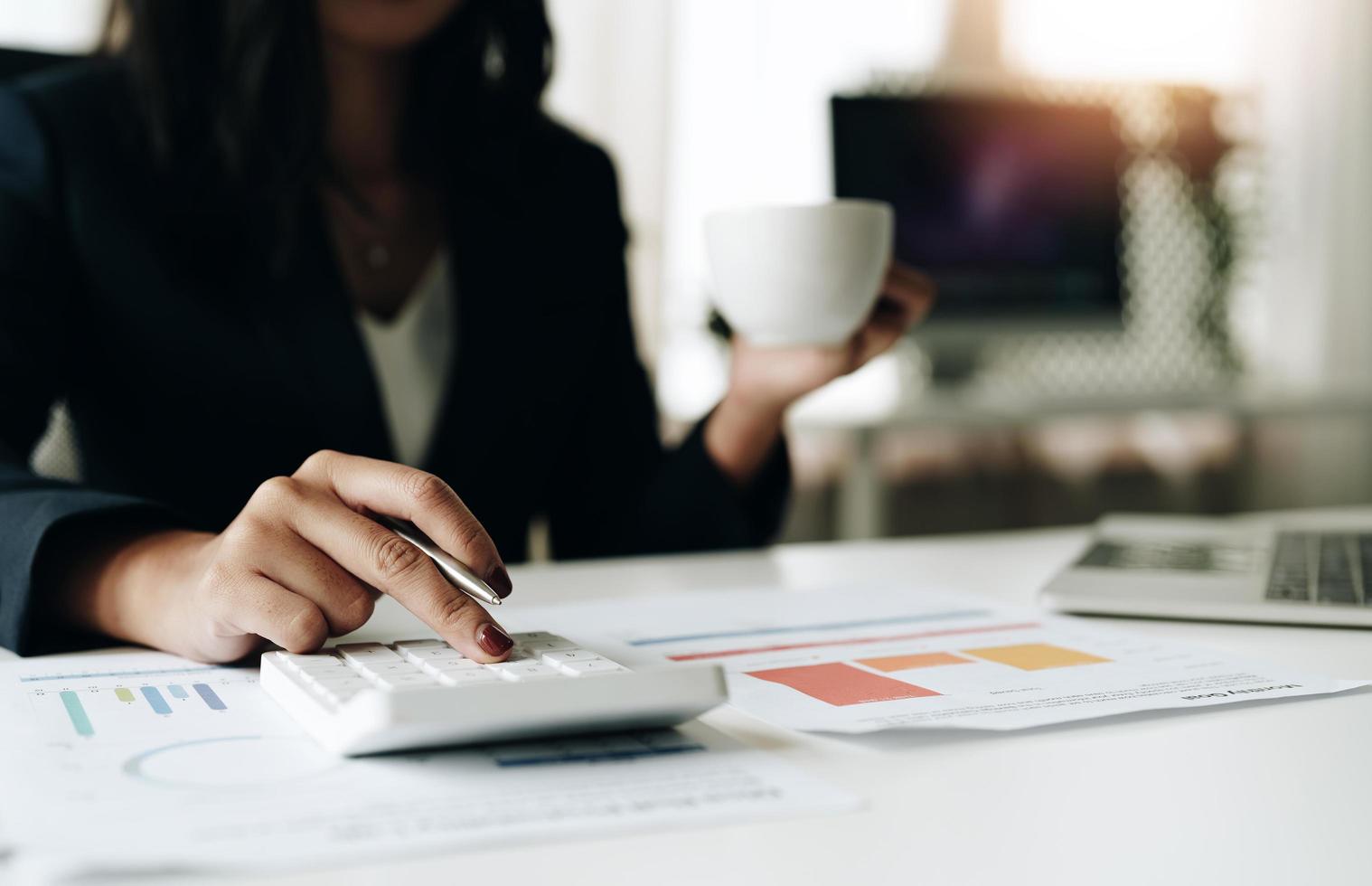 Close up Business woman using calculator for do math finance on desk in office and business working background, tax, accounting, statistics and analytic research concept photo