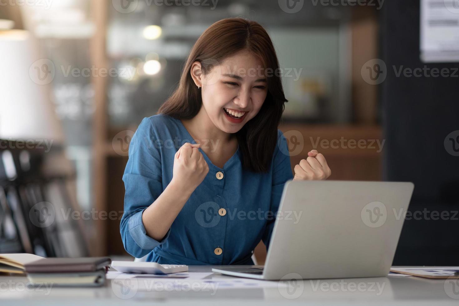 Excited asian female feeling euphoric celebrating online win success achievement result, young woman happy about good email news, motivated by great offer or new opportunity, passed exam, got a job photo