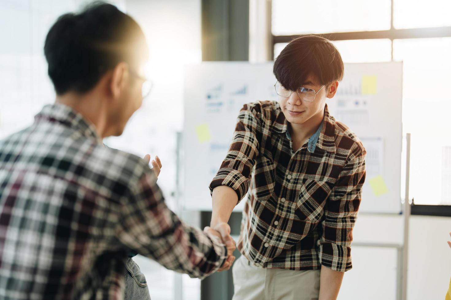 Happy asian business people shaking hands in meeting room photo