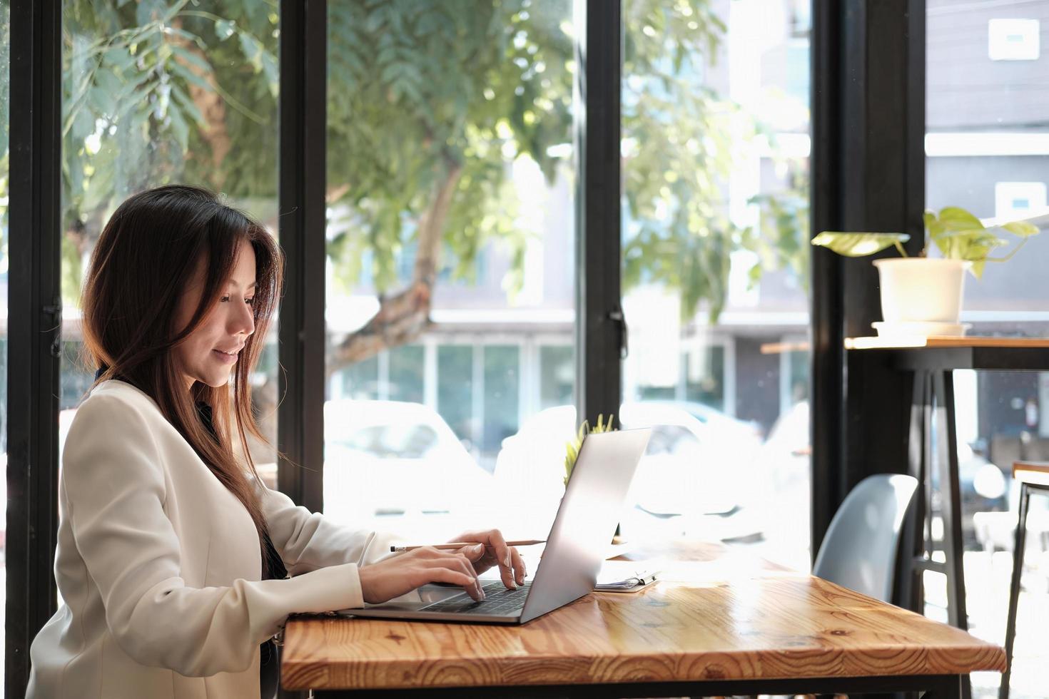 woman journalist freelancer working online on laptop, sitting at desk at home, looking at screen, typing, serious young female writing blog or chatting with friends in social network. photo