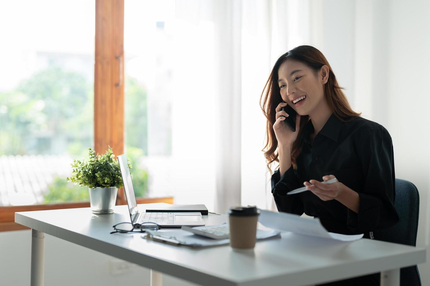 Portrait of attractive entrepreneur asian woman, business woman calling on mobile phone for accounting finance consultant photo