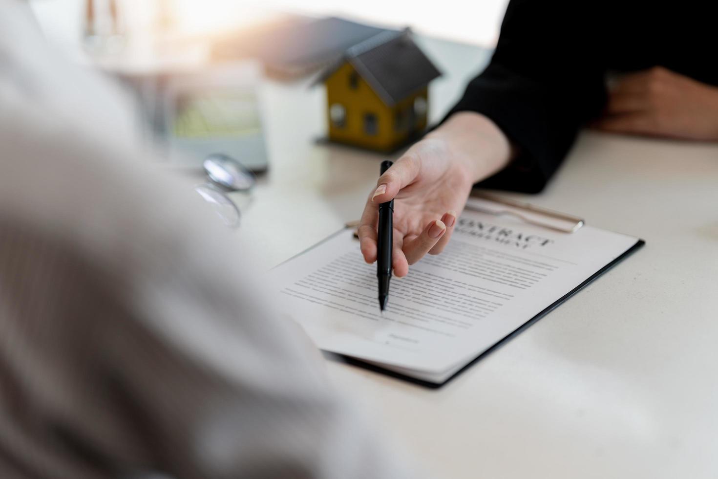 The real estate agent is explaining the house style to the clients who come to contact to see the house design and the purchase agreement photo