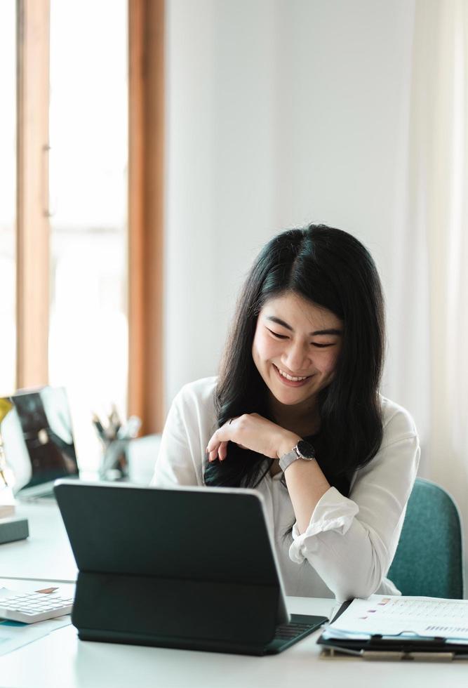 Portrait of Happy Young attractive business woman using digital laptop computer. do math finance on wooden desk, tax, accounting, report statistics and analytical research technology concept photo