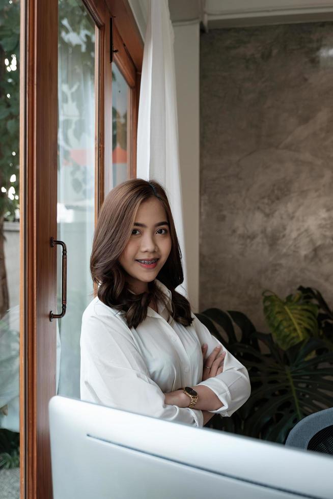 Portrait of entrepreneur young asian woman, business woman arms crossed on modern office photo