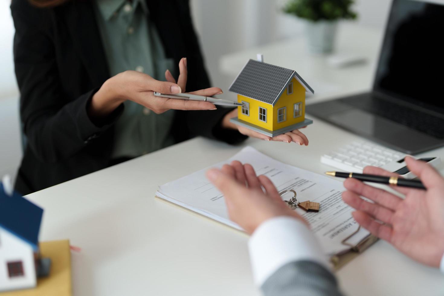 Real estate agent offered home sales and explained the terms of signing the house purchase contract and free home insurance, Finance and after-sales service concept photo