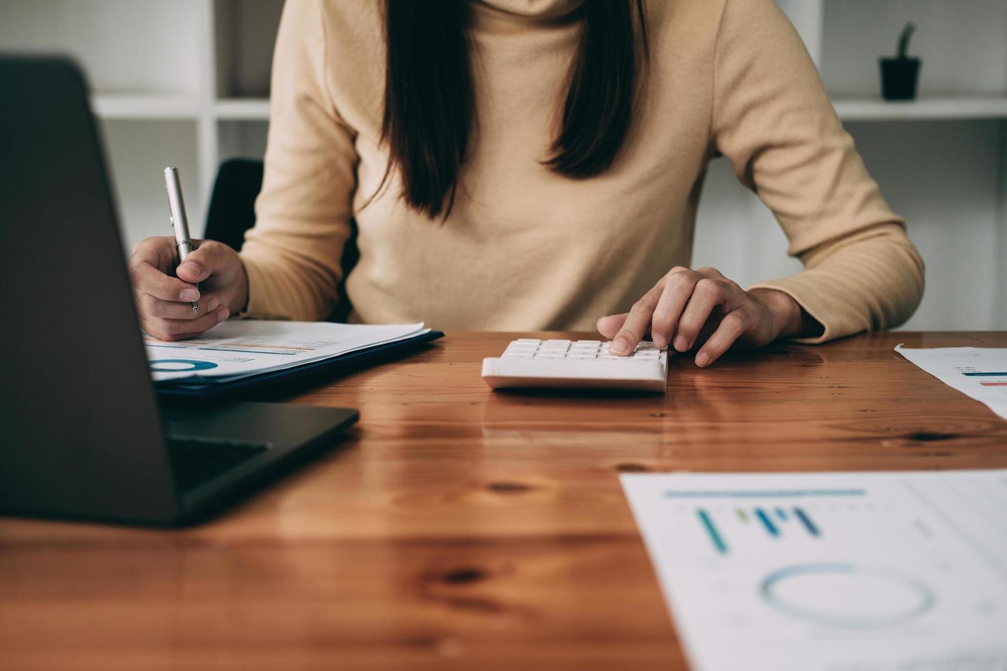 cerrar la mano del contador que trabaja con computadora y calculadora para gastos comerciales y financieros foto