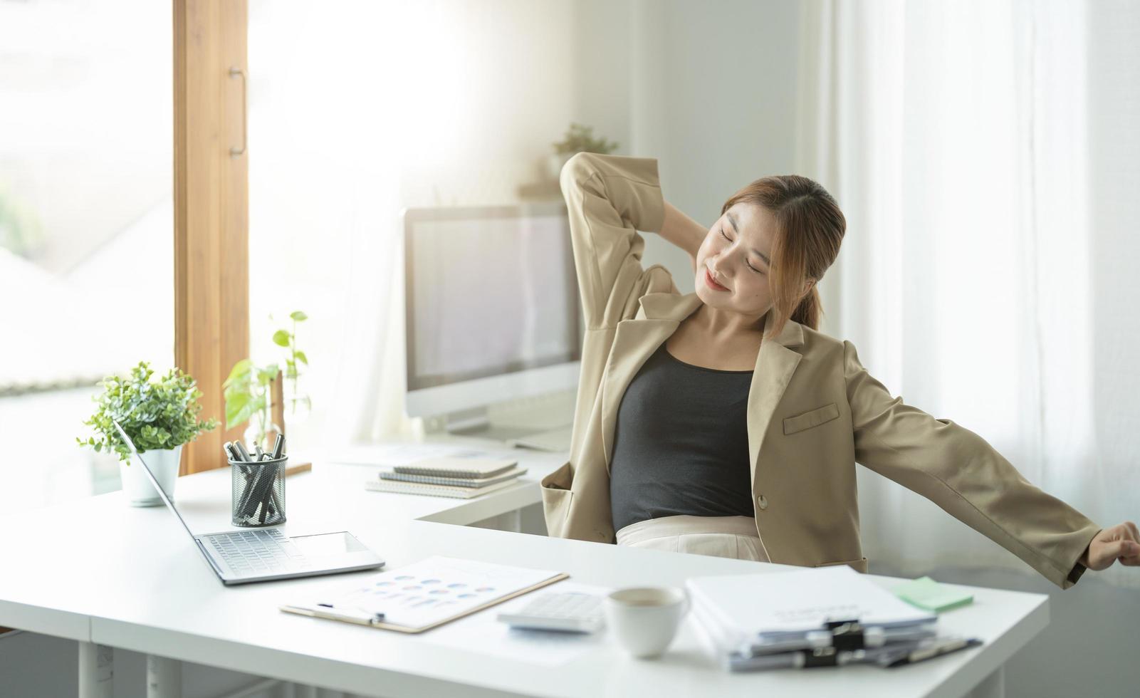 Young asian business woman having break and resting after solving task, business relaxing concept. photo