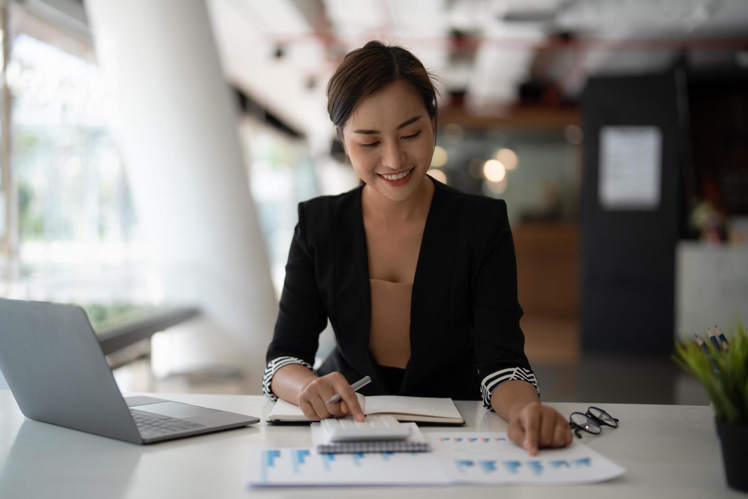 employee accountant woman hand press on calculator for make financial report or company's profit monthly at desk , bookkeeper job and work from home concept photo