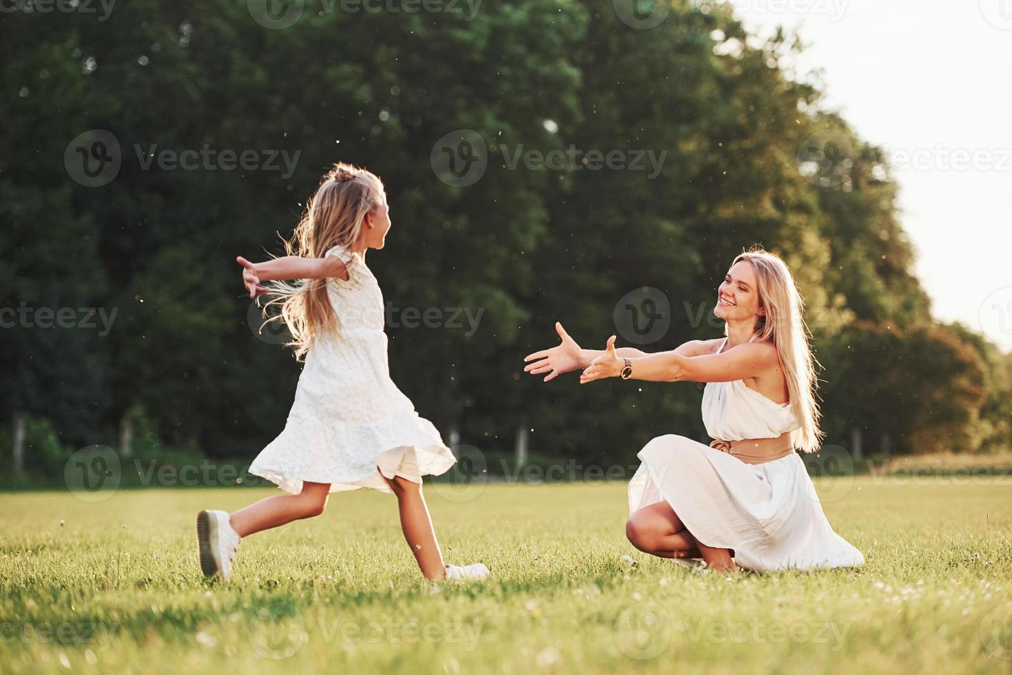 Finally we met. Mother and daughter enjoying weekend together by walking outdoors in the field. Beautiful nature photo