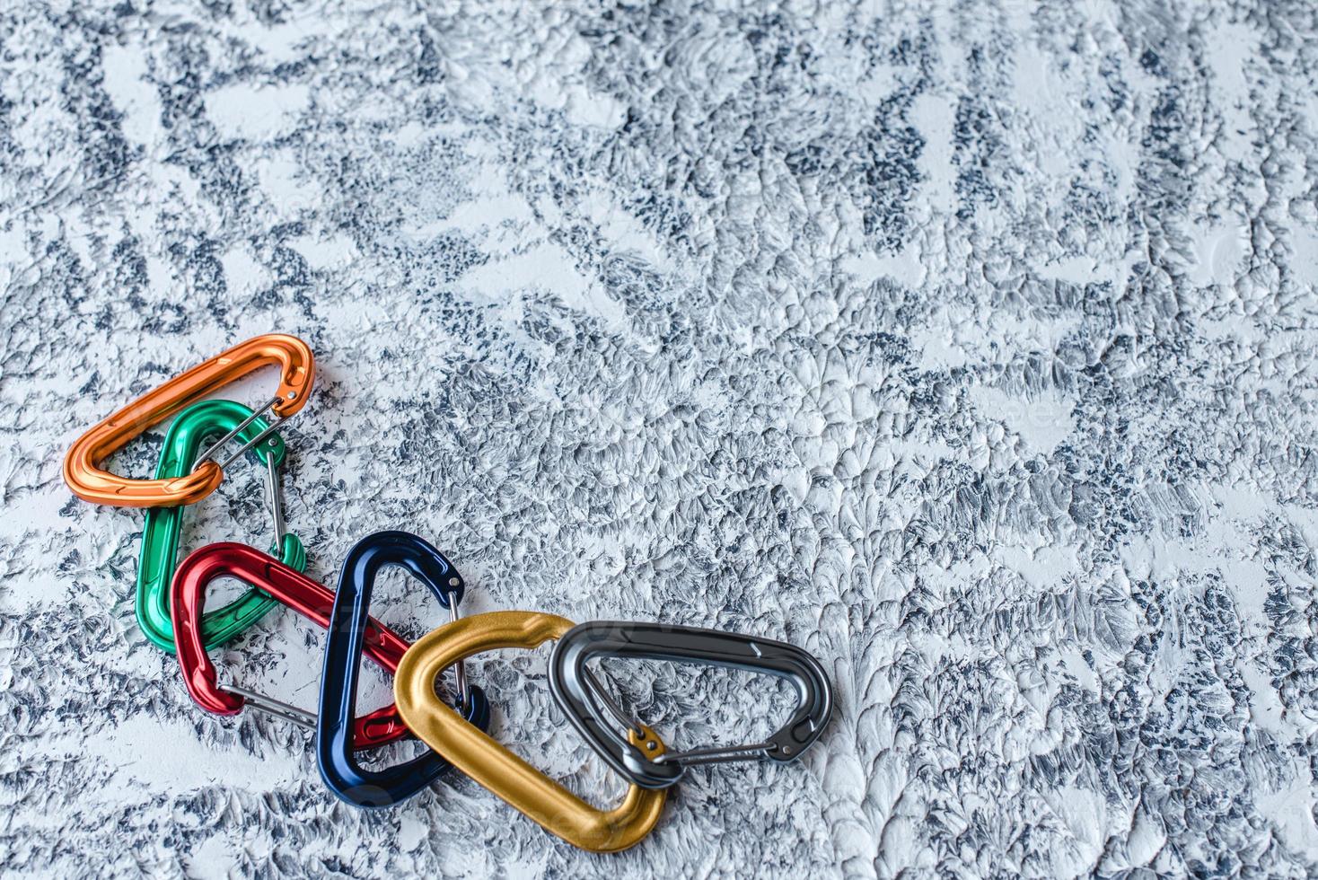Variety of colors. Isolated photo of climbing equipment. Part of carabiner lying on the white and grey colored surface