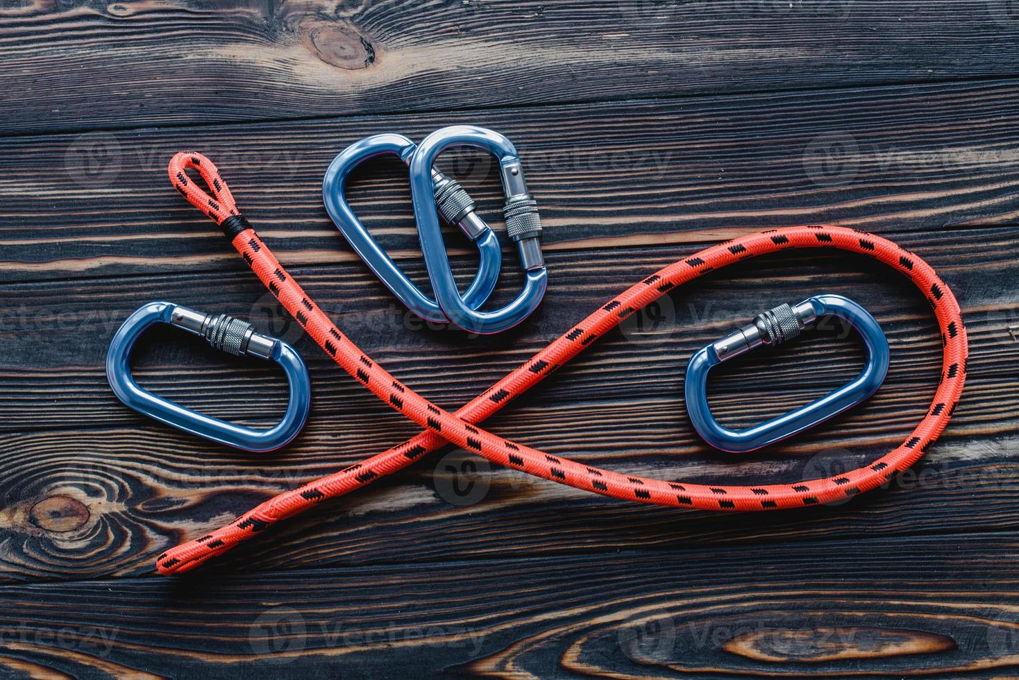 Conception of extreme sports. Isolated photo of climbing equipment. Part of carabiner lying on the wooden table