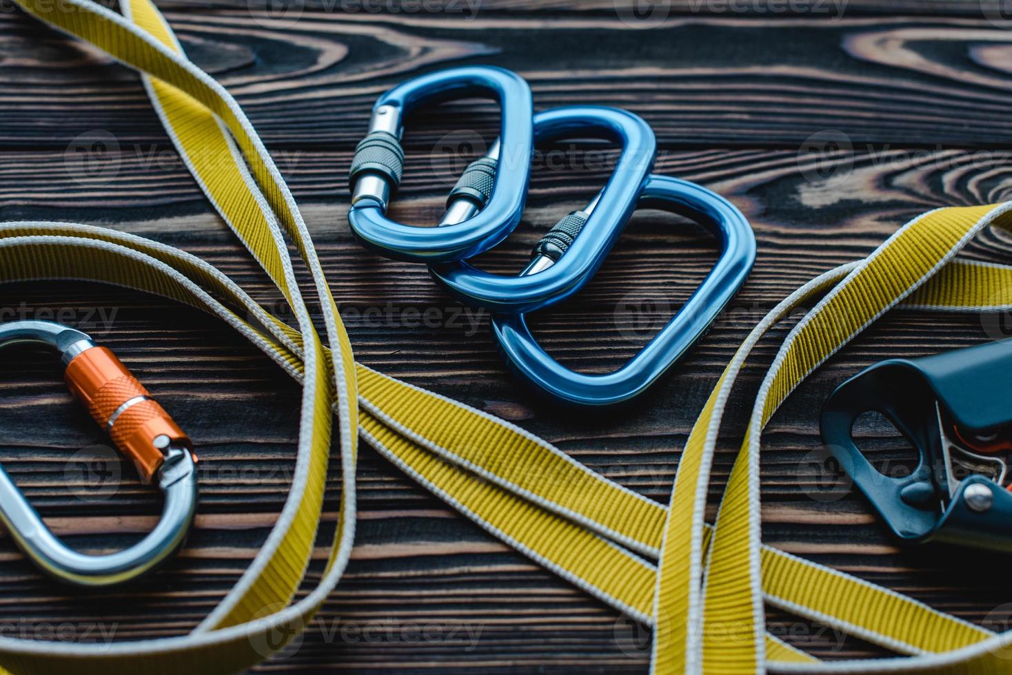 Need to connect it all together. Isolated photo of climbing equipment. Parts of carabiners lying on the wooden table