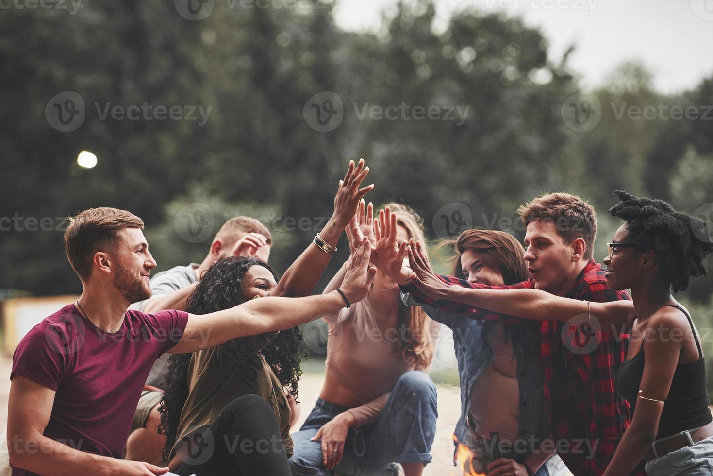Celebrating success. Group of people have picnic on the beach. Friends have fun at weekend time photo