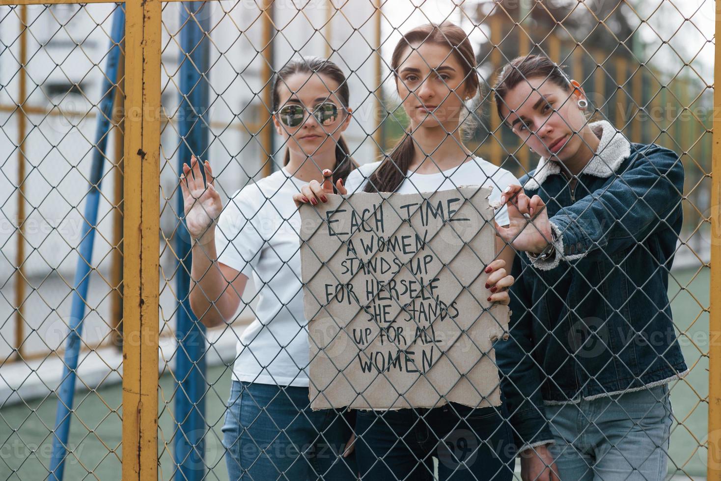 cita en el papel. grupo de mujeres feministas tienen protesta por sus derechos al aire libre foto