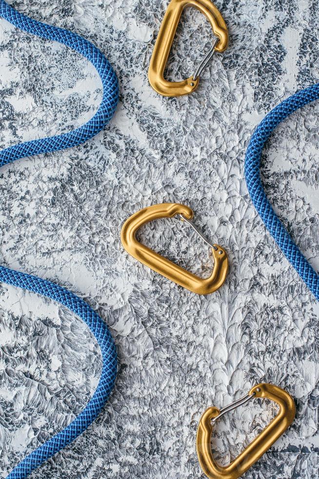 Snap hooks. Isolated photo of climbing equipment. Part of carabiner lying on the white and grey colored table