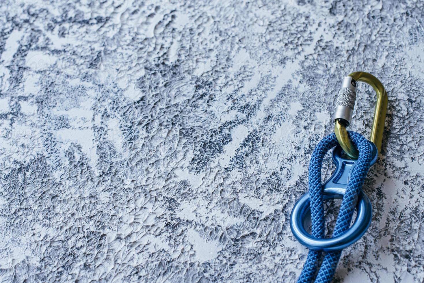 Particle view. Isolated photo of climbing equipment. Part of carabiner lying on the white and grey colored surface