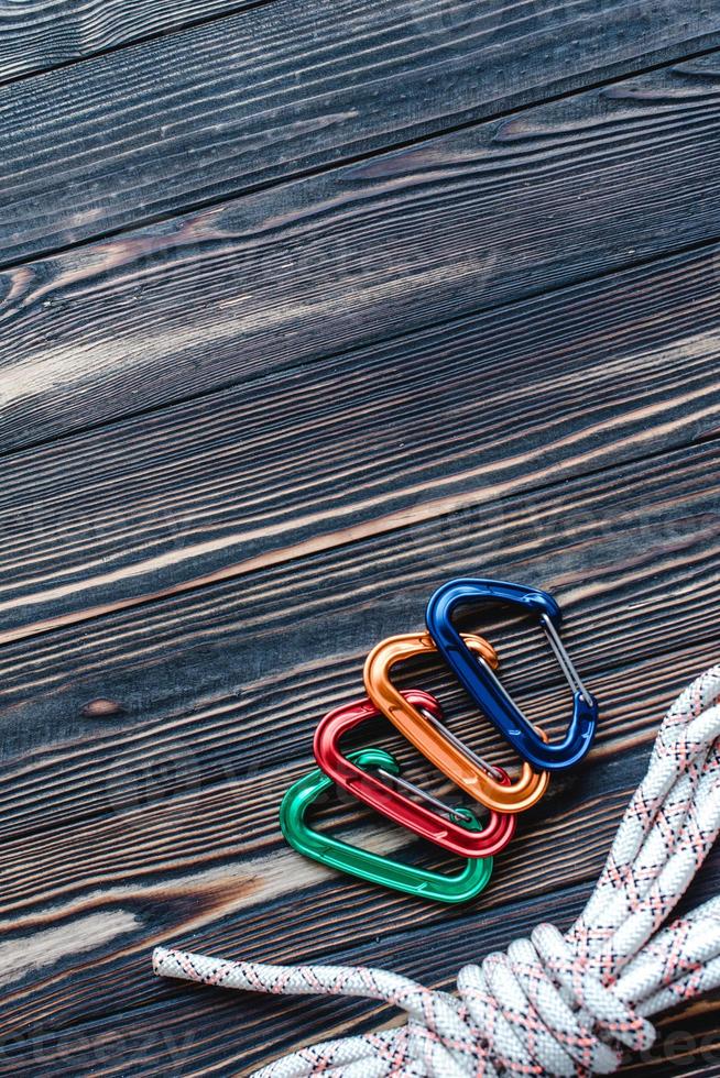 Nice polished. Isolated photo of climbing equipment. Part of carabiner lying on the wooden table