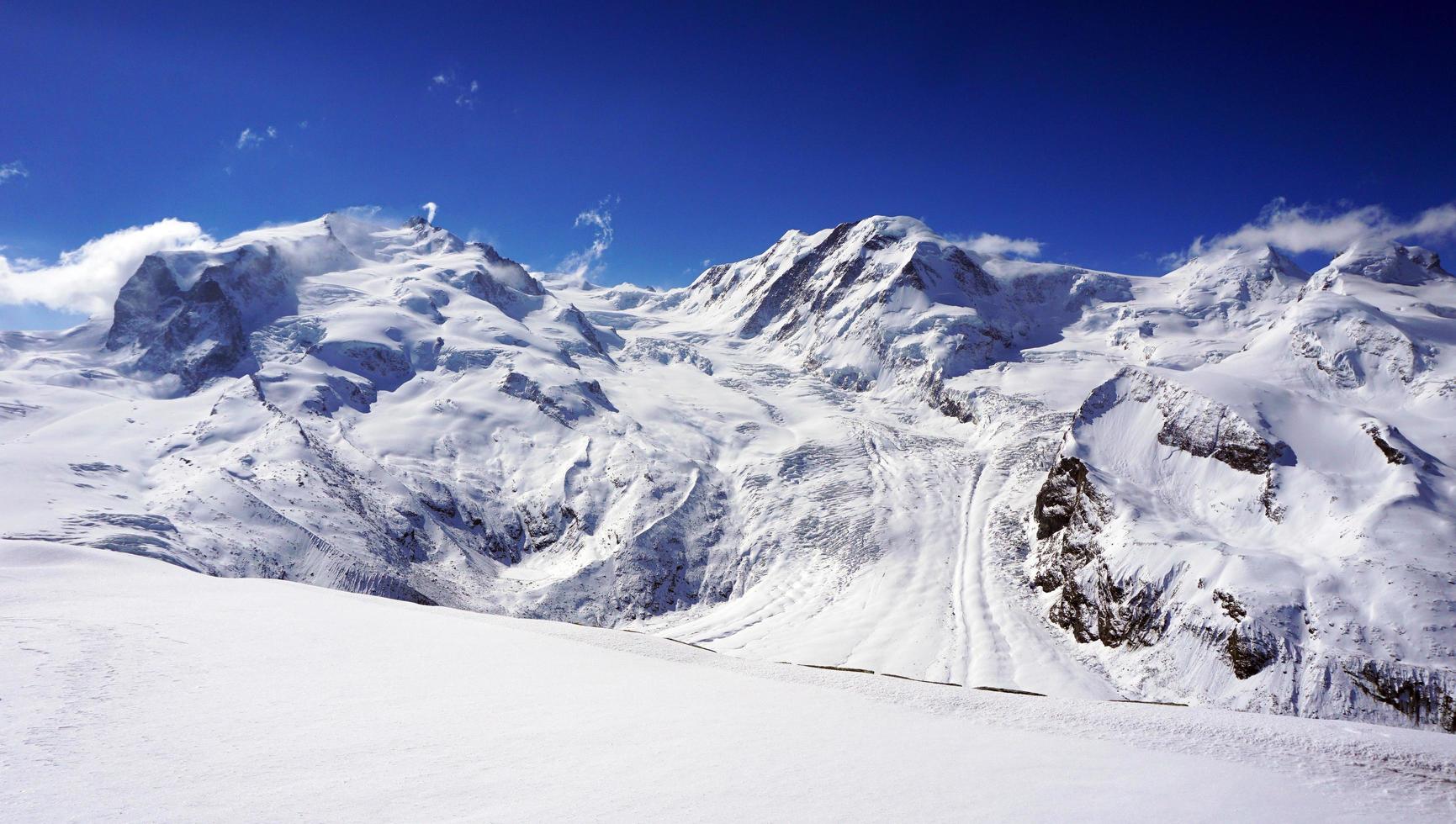 Alpes nevados montañas y cielo azul foto