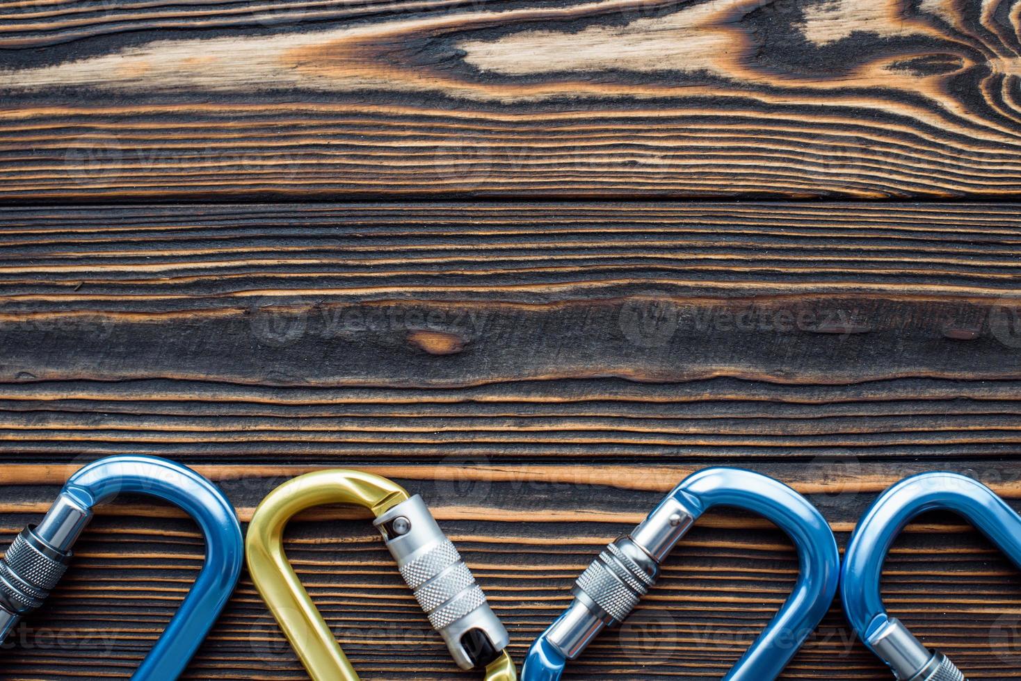 Don't forget to buy one. Isolated photo of climbing equipment. Parts of carabiners lying on the wooden table