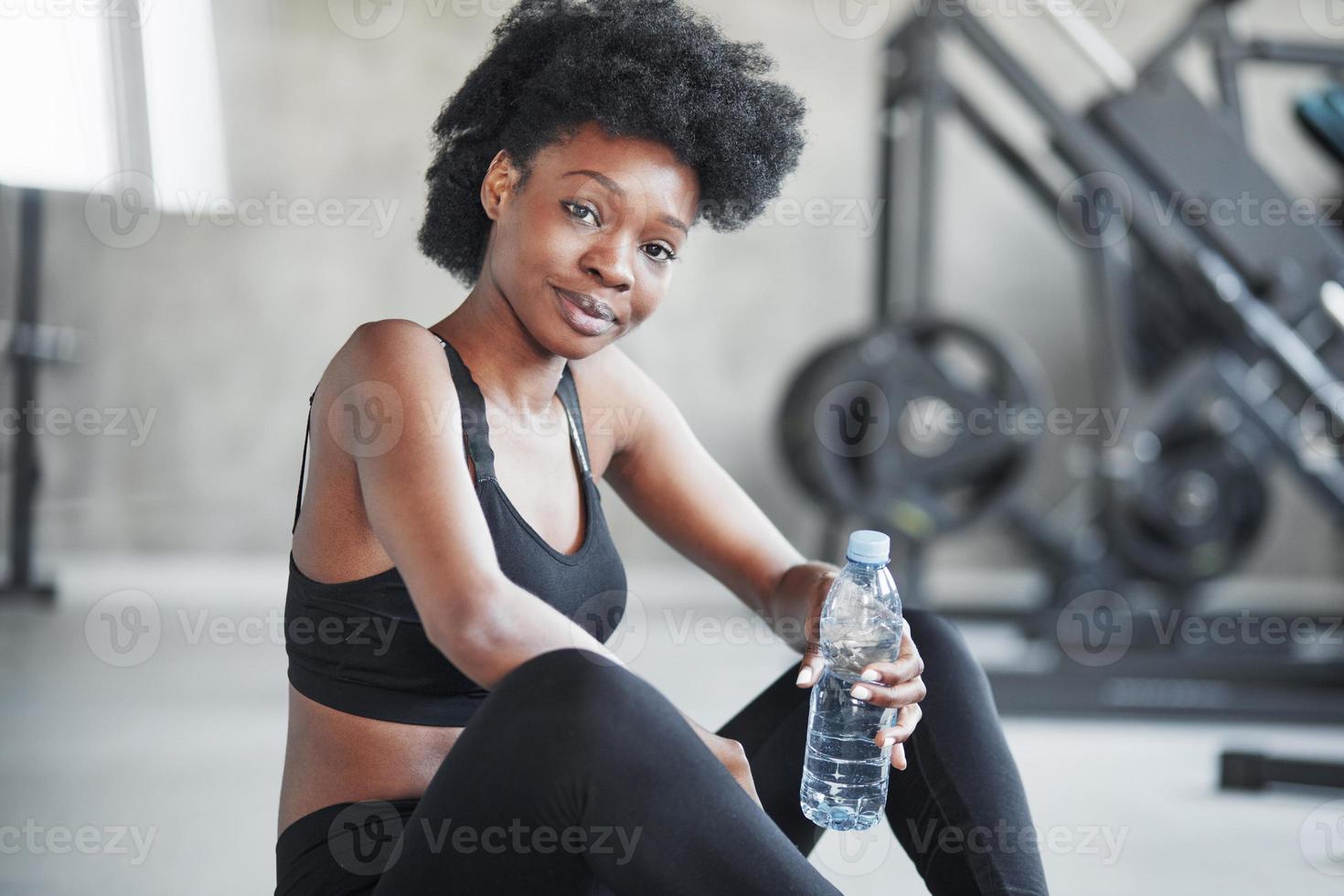 Thoughtful look. African american woman with curly hair and in sportive  clothes have fitness day in the gym 8457439 Stock Photo at Vecteezy