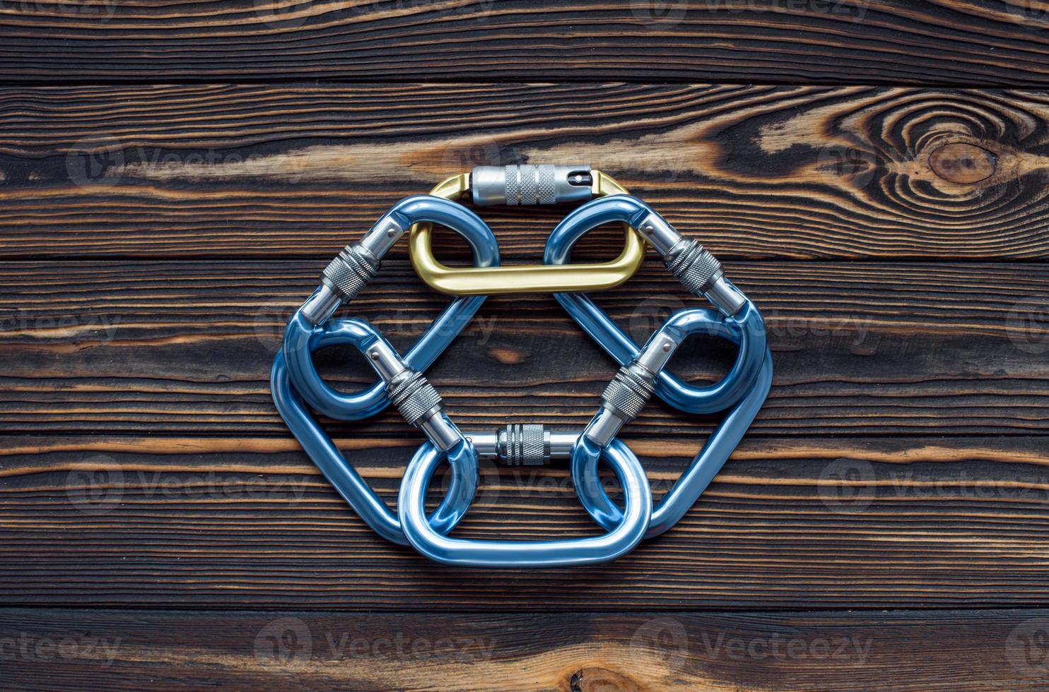 Circle of objects. Isolated photo of climbing equipment. Parts of carabiners lying on the wooden table