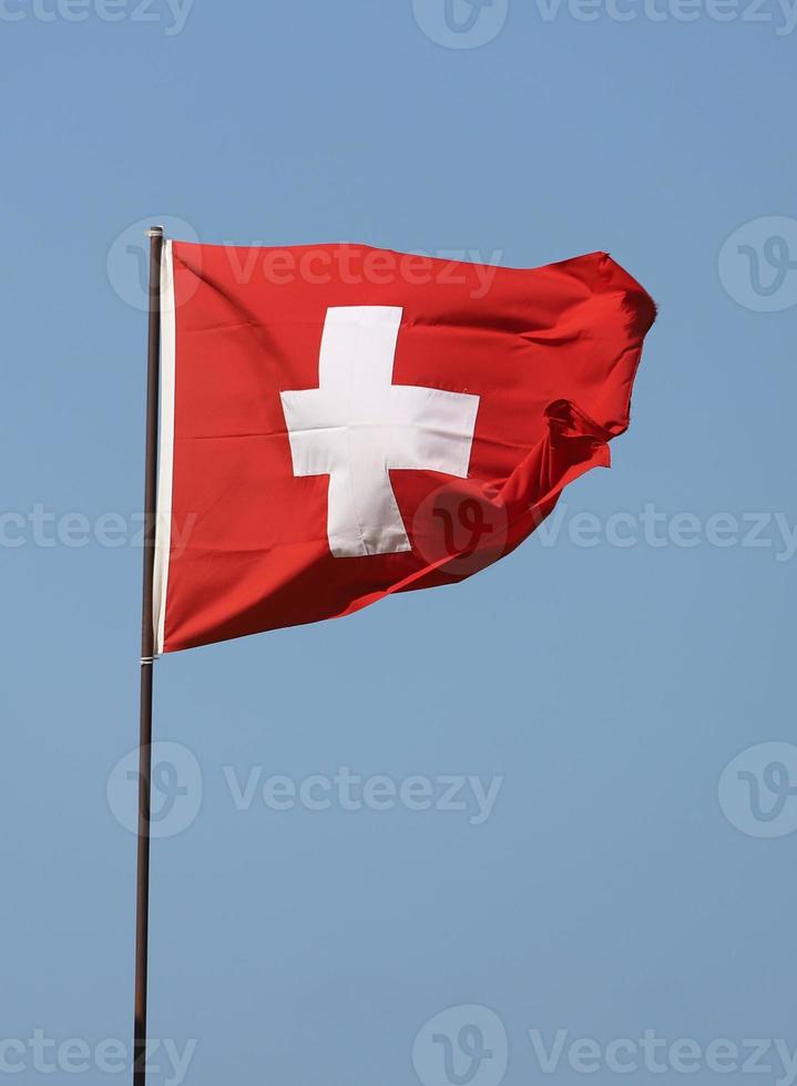 Swiss flag flying on flagpole photo