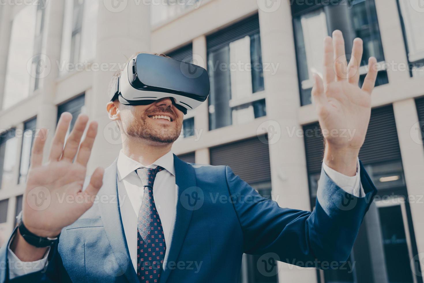 Professional impressed worker standing outside alone and using VR glasses to visualize projects photo