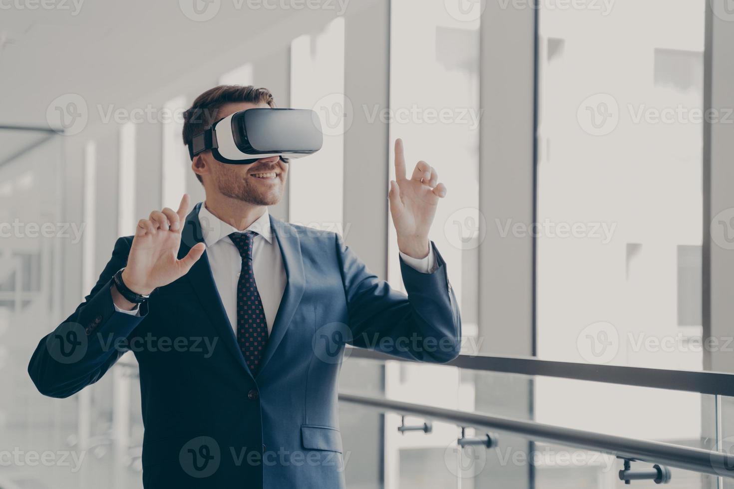 Handsome smiling businessman in vr headset using innovative technologies for business at work photo