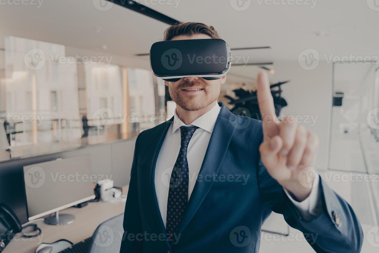 CEO man stands in office with VR headset and interacts with application virtual interface photo
