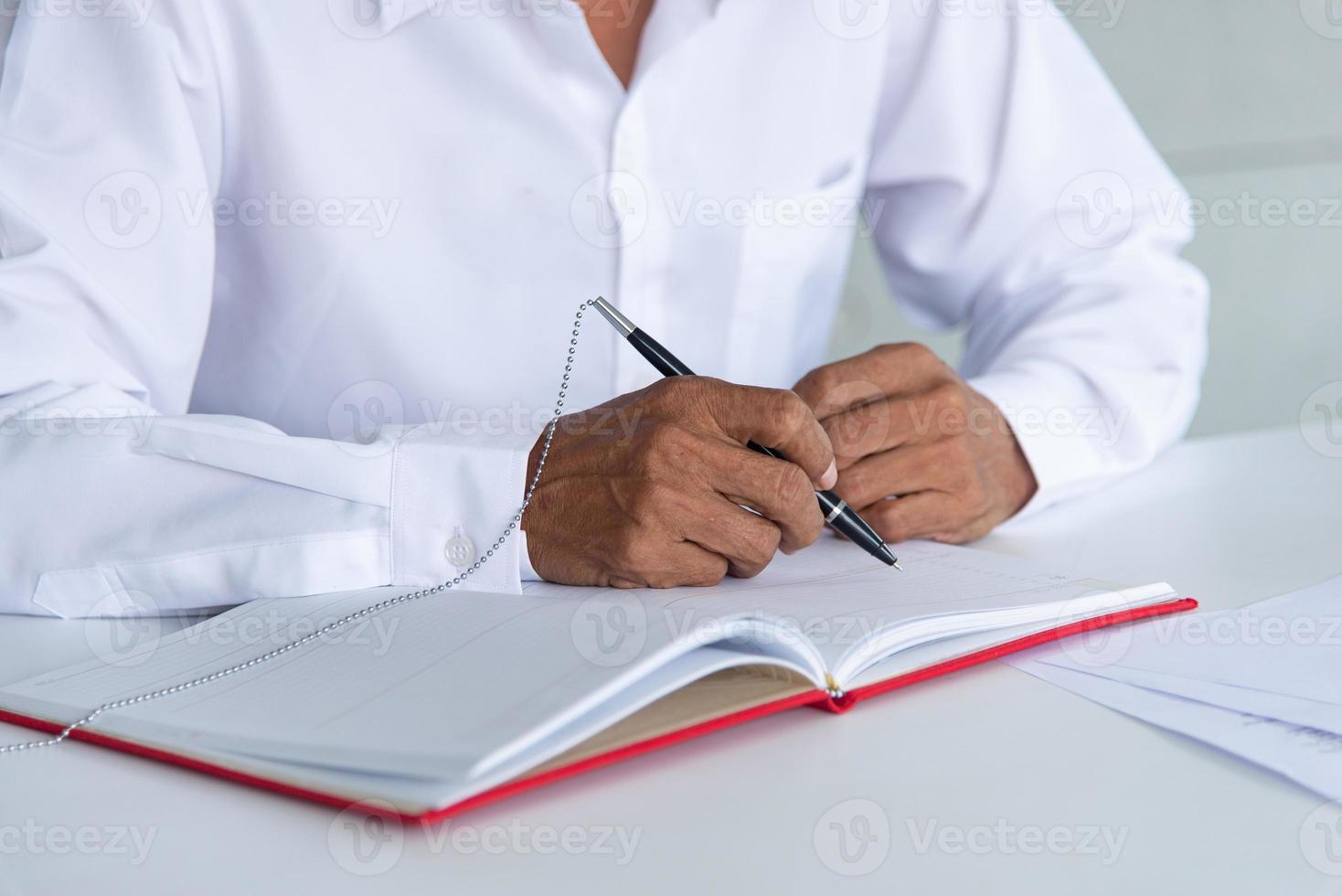 trabajo desde casa y concepto de distanciamiento social. anciano de negocios asiático que trabaja en un espacio de trabajo conjunto o en una sala de reuniones. firma de signo de hombre de envejecimiento. foto