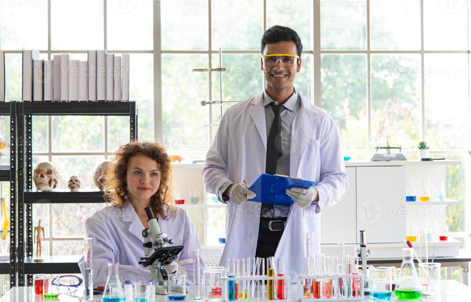 Hermoso joven científico o investigadores que colocan equipos de protección personal para prevenir infecciones por virus o bacterias. investigador descubre la vacuna covid-19 en laboratorio. foto