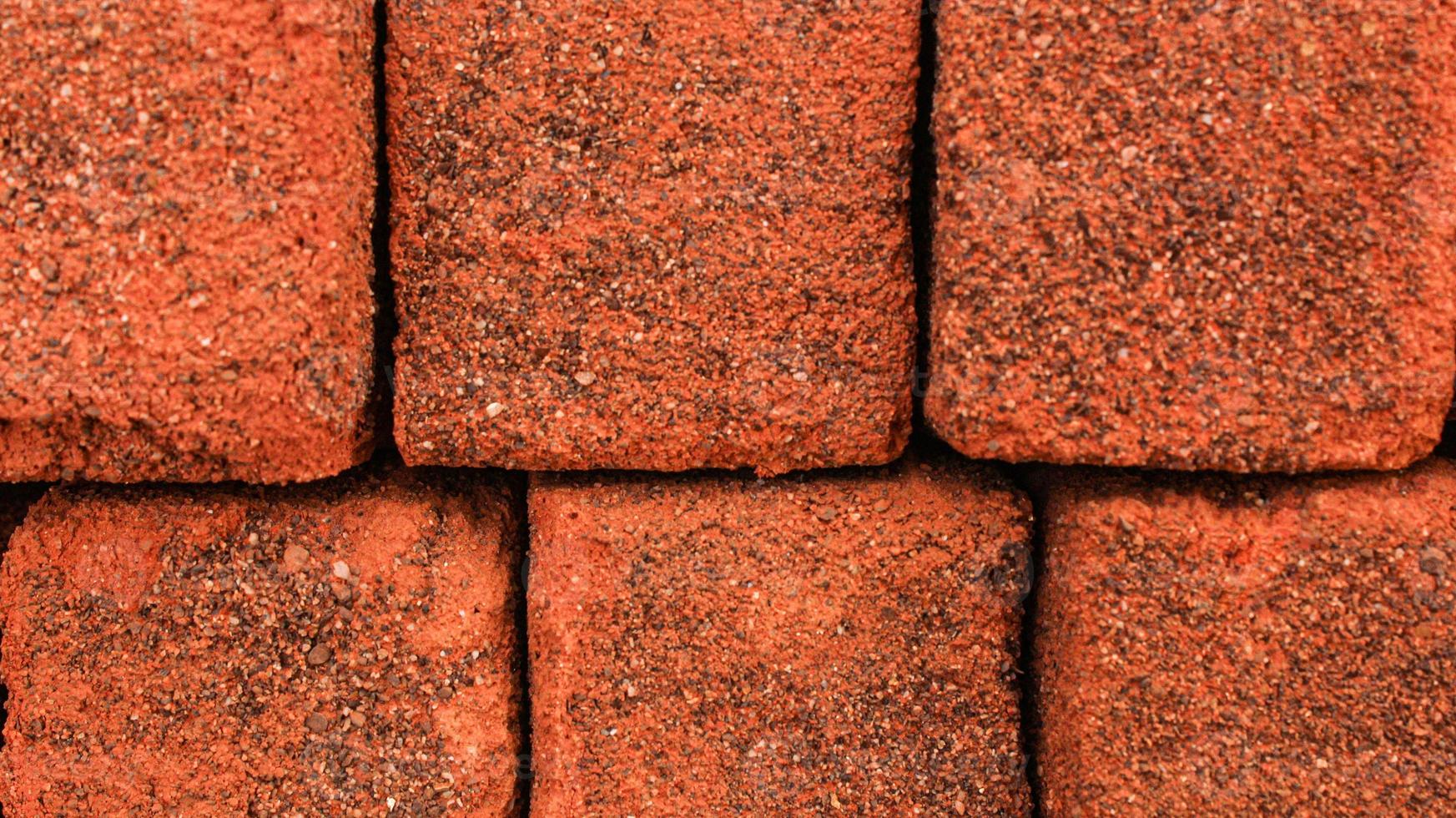 Arrangement of solid clay bricks used for construction, dark red brick, closeup view of red bricks as building materials, arrangement of brickwork photo