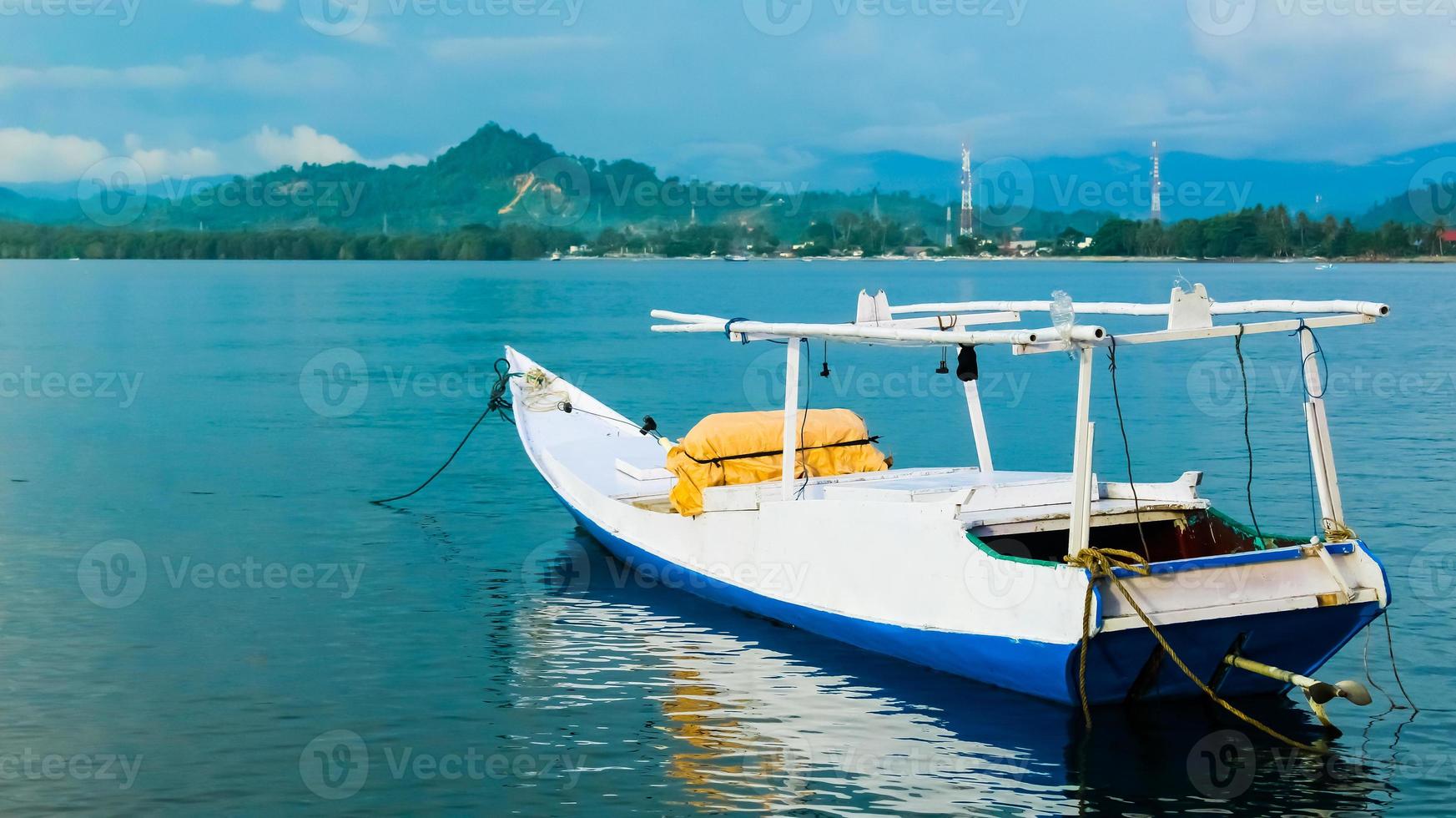 A motorboat used by fishermen. Travel at Pasangkayu Beach in Pasangkayu Regency, Indonesia. Tropical landscape with motorboat. Scenic back view motor boat ship on clean blue sea water. photo